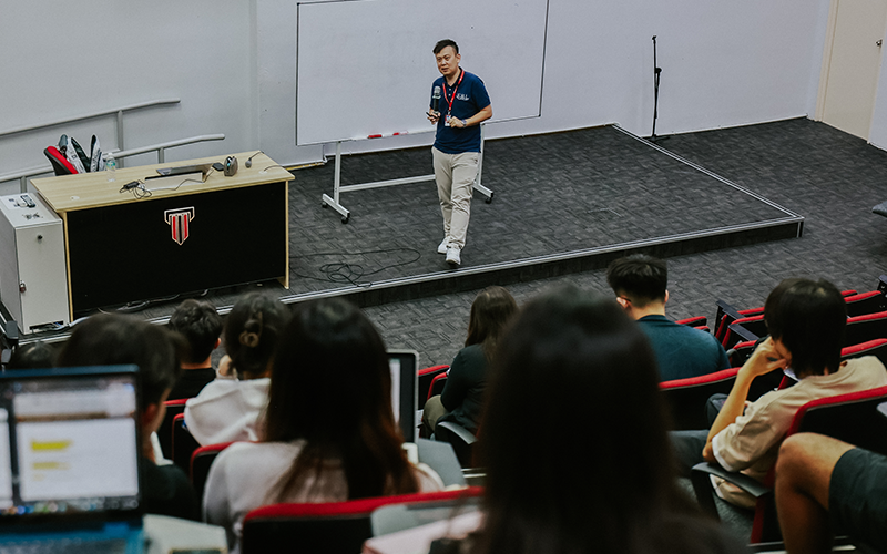 Taylor's lecturer explaining concept in the lecture hall